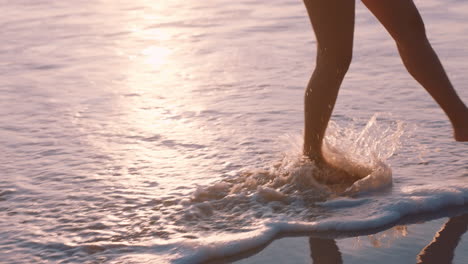 Nahaufnahme-Der-Füße-Einer-Frau,-Die-Bei-Sonnenuntergang-Barfuß-Am-Strand-Läuft-Und-Die-Sanft-Plätschernden-Wellen-Genießt.-Weibliche-Touristin-Im-Sommerurlaub