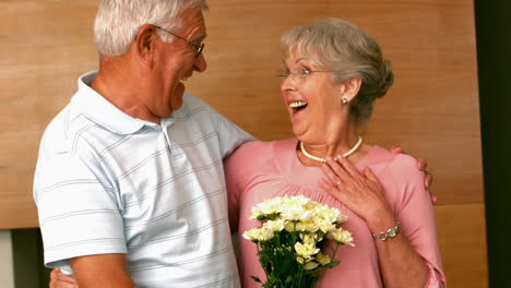 Senior-man-surpising-partner-with-flowers