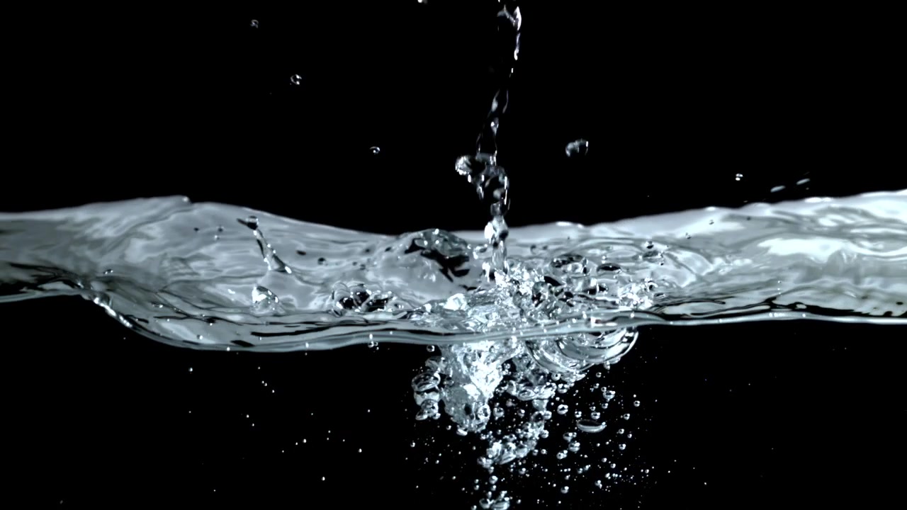Gocce d'acqua che schizzano su sfondo nero al rallentatore
