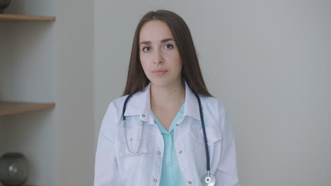 looking at the camera listening woman doctor looks at the camera and listens to the patient. a video conference listener. portrait of a doctor