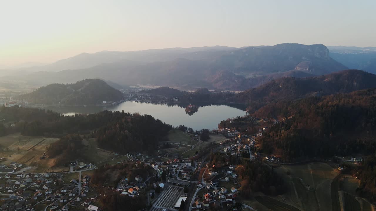 La vista cinematografica mostra il villaggio di Bled e l'iconico lago all'alba con le montagne, Slovenia