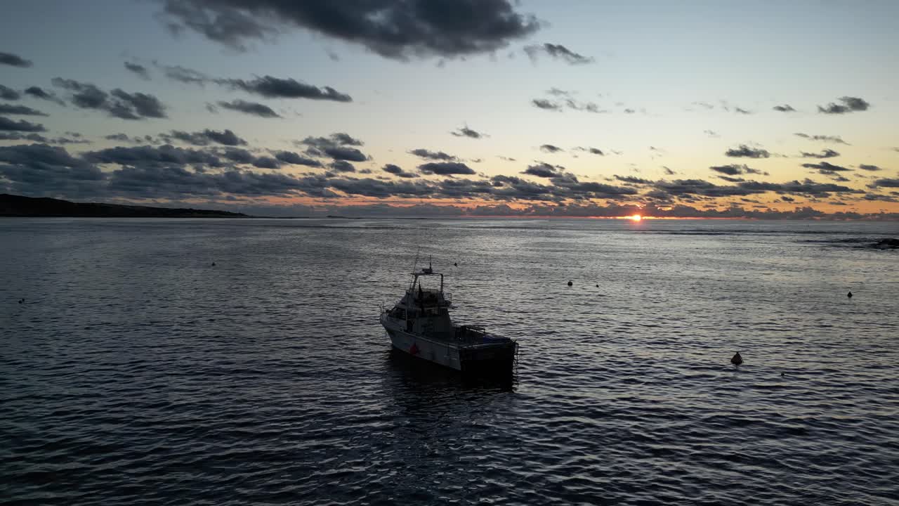 vista aérea de un barco turístico en el mar frente a la puesta de sol dorada y las nubes en el cielo por la noche - australia, río margaret