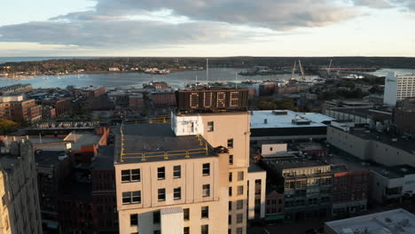 beautiful oscillating aerial shot of the time and temperature building in front of casco bay in portland, maine