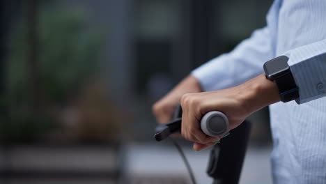 Closeup-hands-on-electric-scooter-handlebar-riding-downtown.-Urban-traveler.