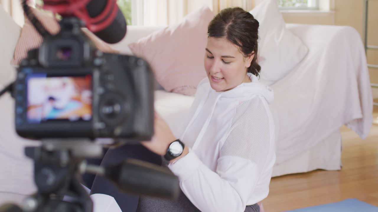 백인 블로거 여성이 집에서 비디오를 만들고 있습니다.