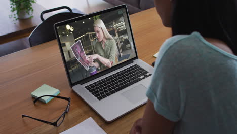 african american woman having a video call with female office colleague on laptop at home