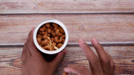 hand pick cashew nut from a container top view ,