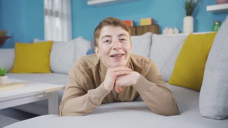 un adolescente lindo con aparatos ortopédicos guiñando a la cámara.