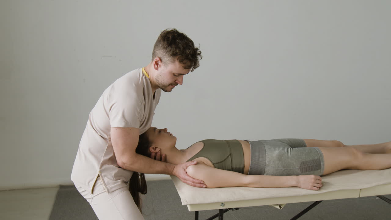 Physiotherapist Performing Neck Adjustment on Patient