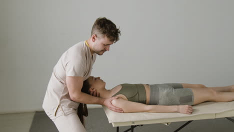 physiotherapist performing neck adjustment on patient