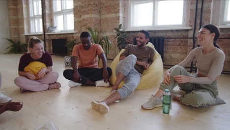 Group of Young Multiethnic Dancers Chatting after Training in Studio