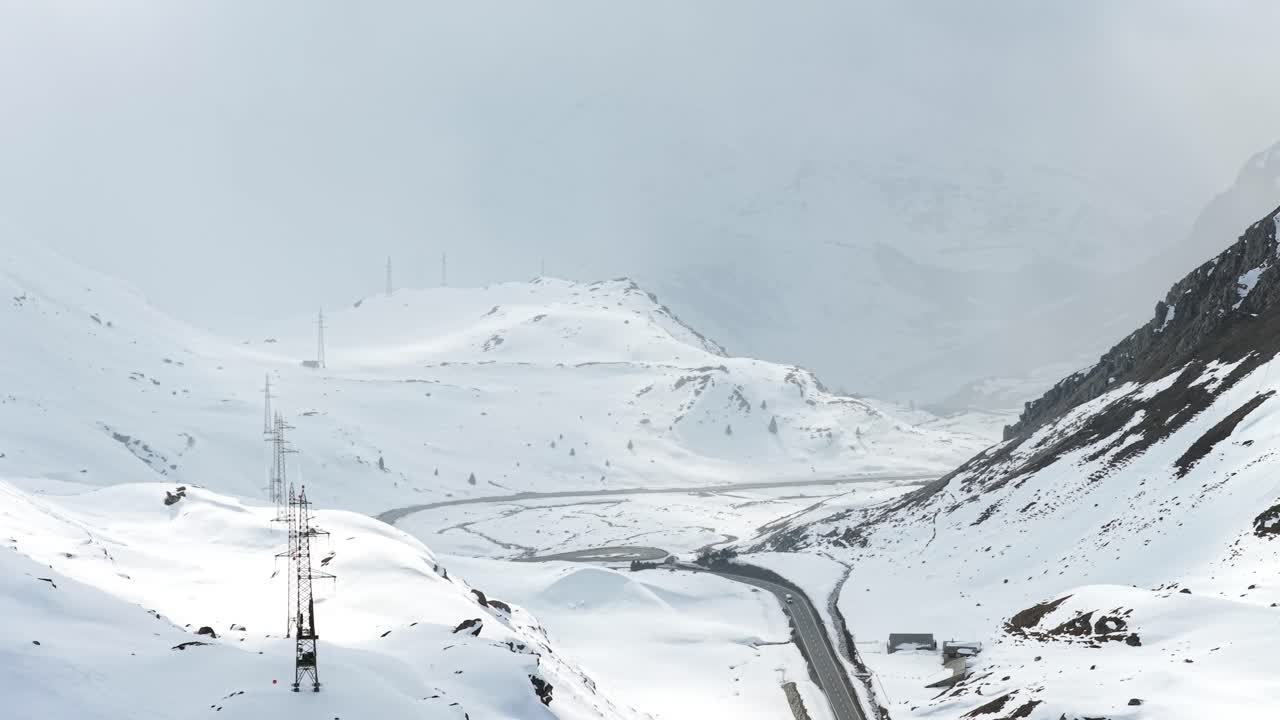 Snowy aerial panorama of winding road through mountain pass, Malojapass, Switzerland