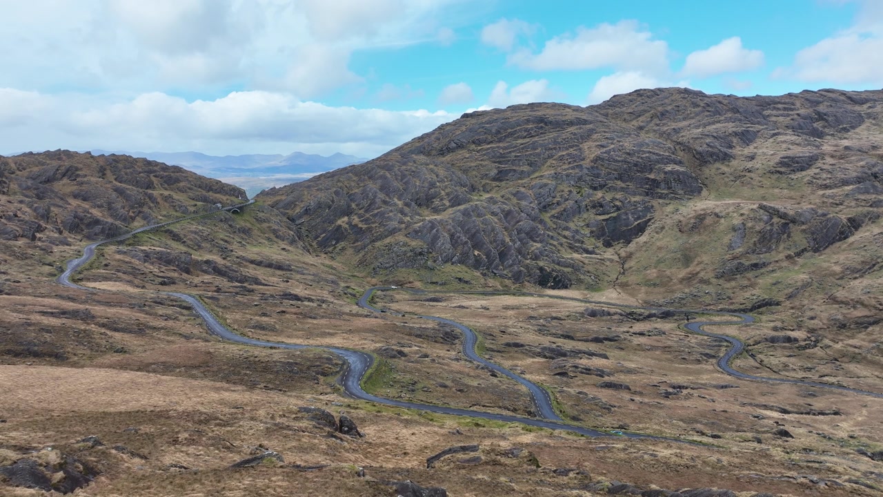 Ripresa aerea statica di una strada che si snoda su per la montagna verso il Passo Healey, al confine tra Cork e Kerry, Irlanda.
