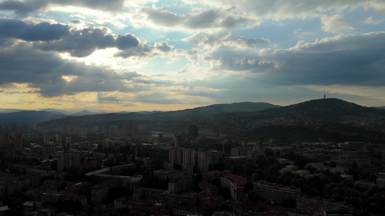 dramatic Aerial drone view of Sarajevo skyline at sunset, modern architecture surrounded by the Dinaric Alps, Bosnia Herzegovina