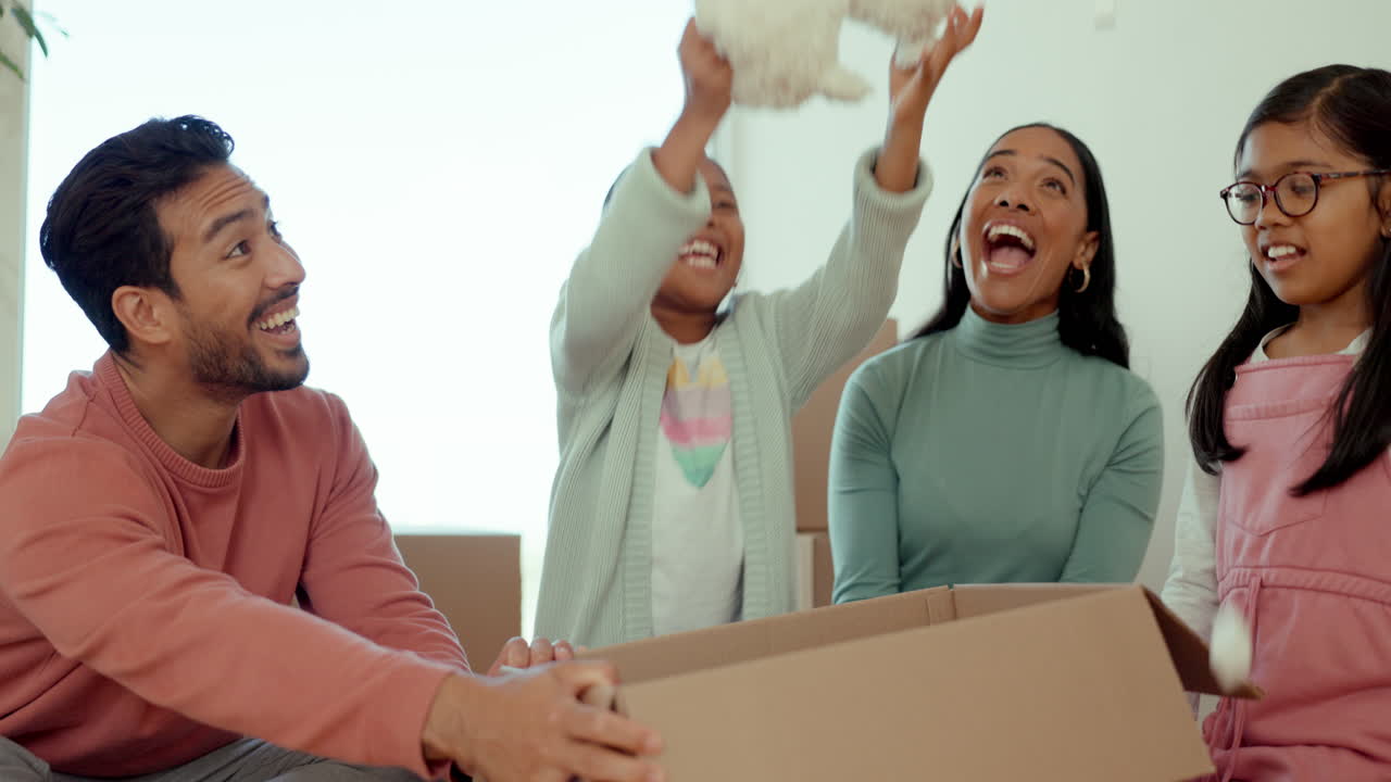 genitori, bambini e scatola aperta nella nuova casa