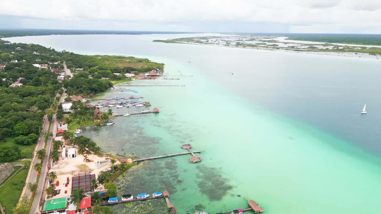 Aerial view of Bacalar, Mexico's turquoise lagoon with boats and lush greenery