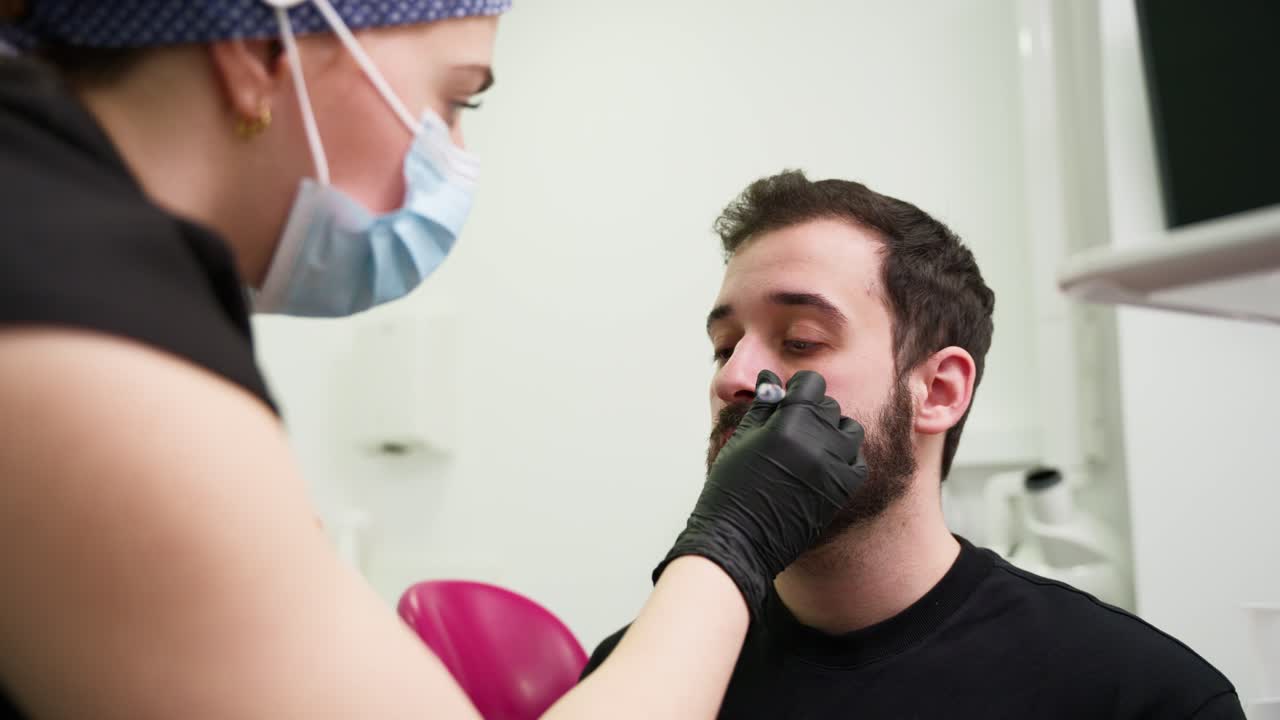 Cosmetologist Marks Man's Face for Aesthetic Procedure in Clinic