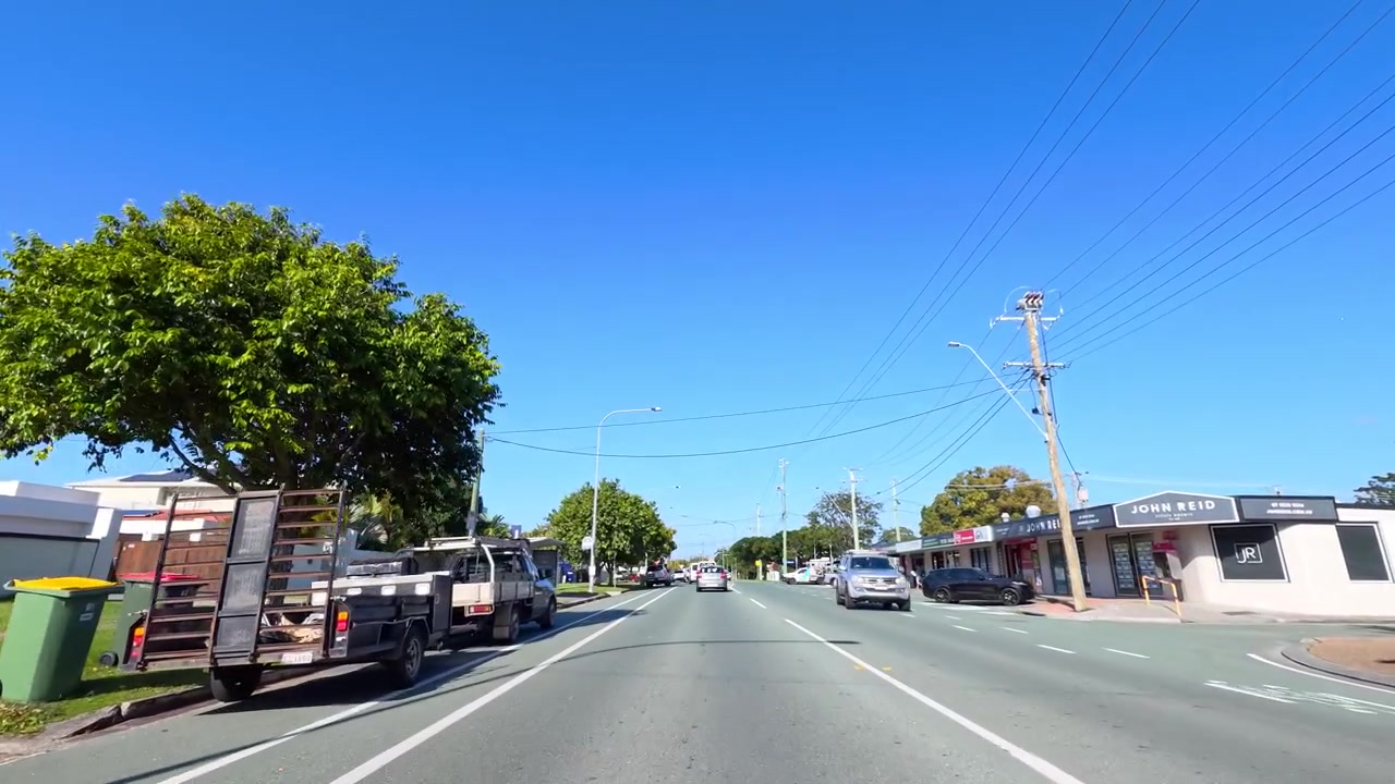 広角ドライブレコーダーの映像が、見通しの良いアスファルトの道を家々や地元の店を通り過ぎながら進む。