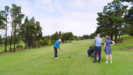 golf players playing golf and knocking golf ball out on golf course on cloudy day