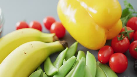 video of fresh fruit and vegetables and bowl of nuts over grey background