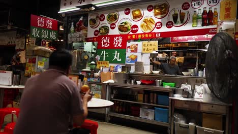 man enjoying food at a bustling street stall