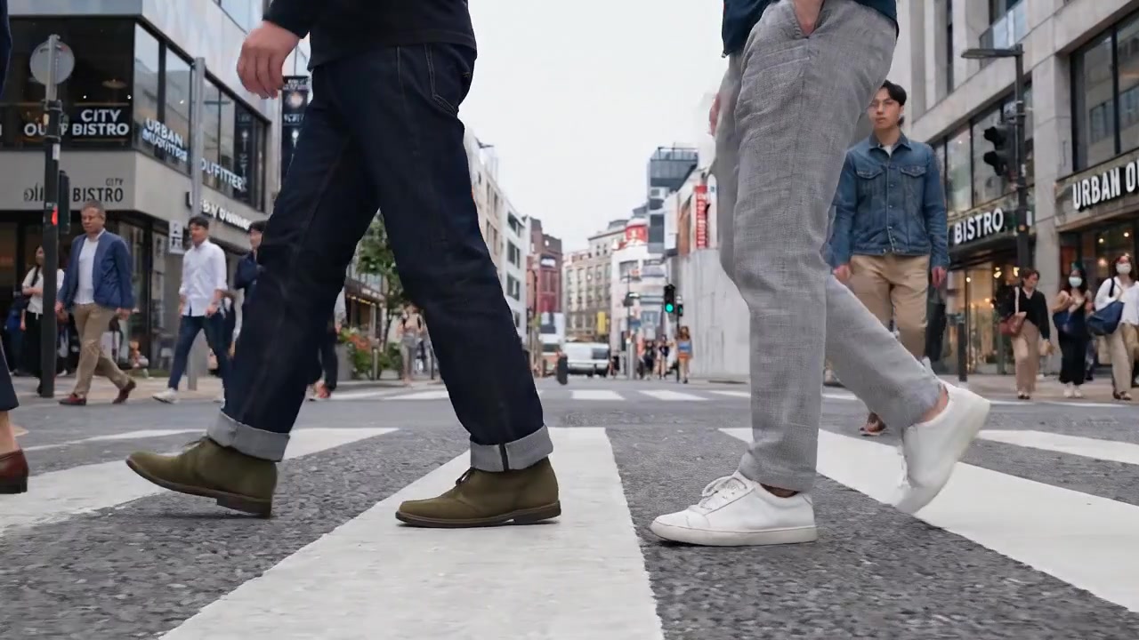 Piétons traversant un carrefour urbain très fréquenté, vue au niveau du sol