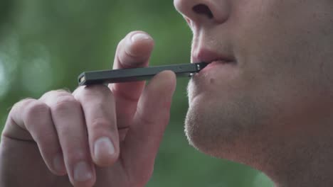 close up of male model smoking vaporizer outside 60fps