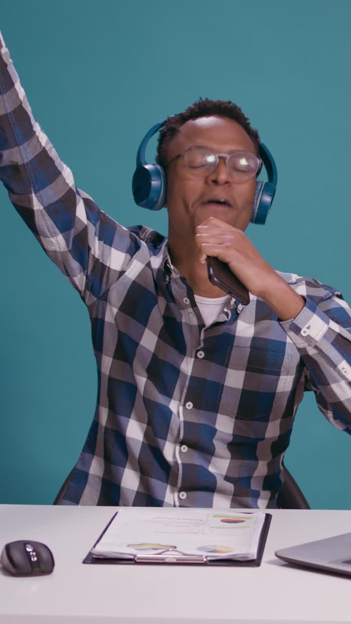 African American man dancing with headphones at work