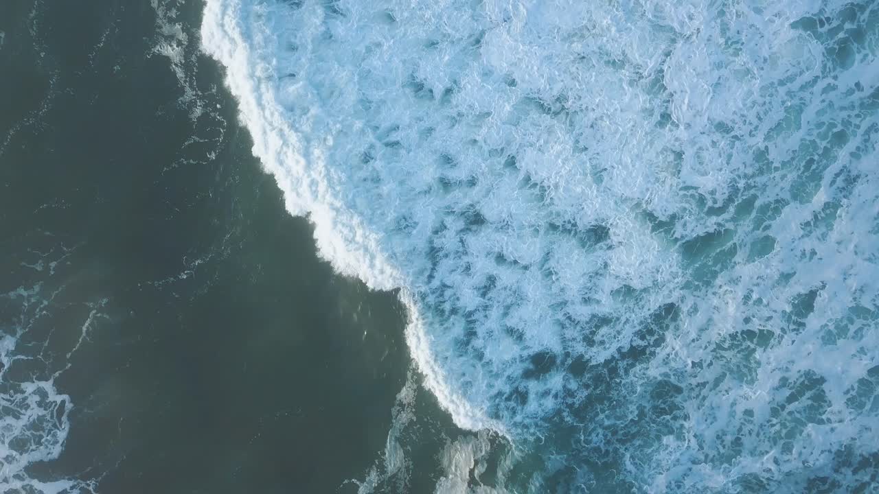Birds eye view in 4k of a massive blue breaking wave in the stormy pacific ocean - Whitewater -Spray - California