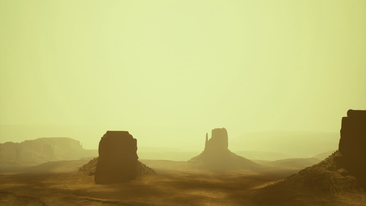 Monument valley landscape reveals iconic rock formations under hazy sky