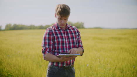 agricultor usando una tableta en un campo de trigo
