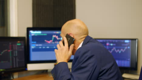 a mature business man chatting on the phone on his office working late