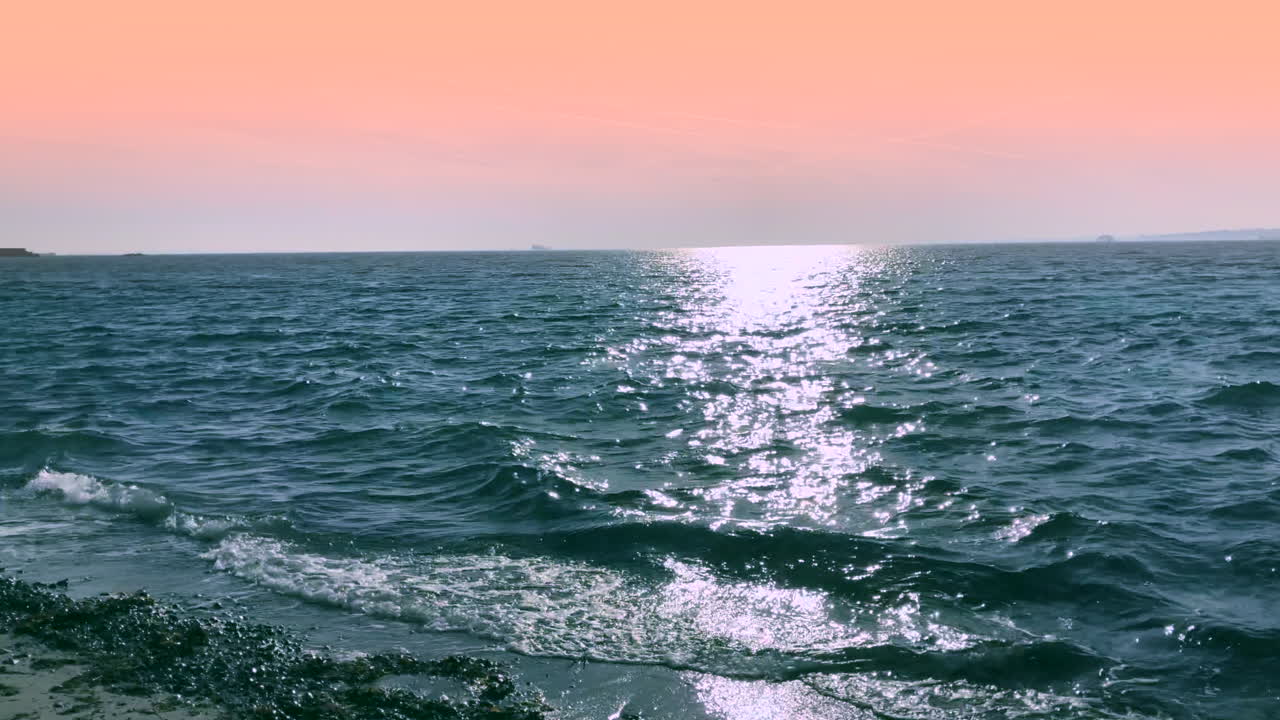 분홍빛 하늘 아래 강렬한 푸른 바다