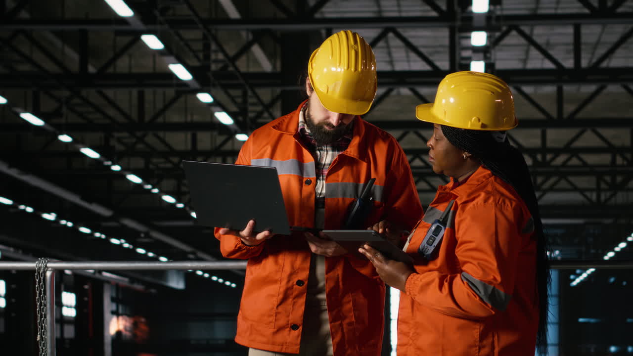 Professional engineers team coordinating production line in large-scale factory