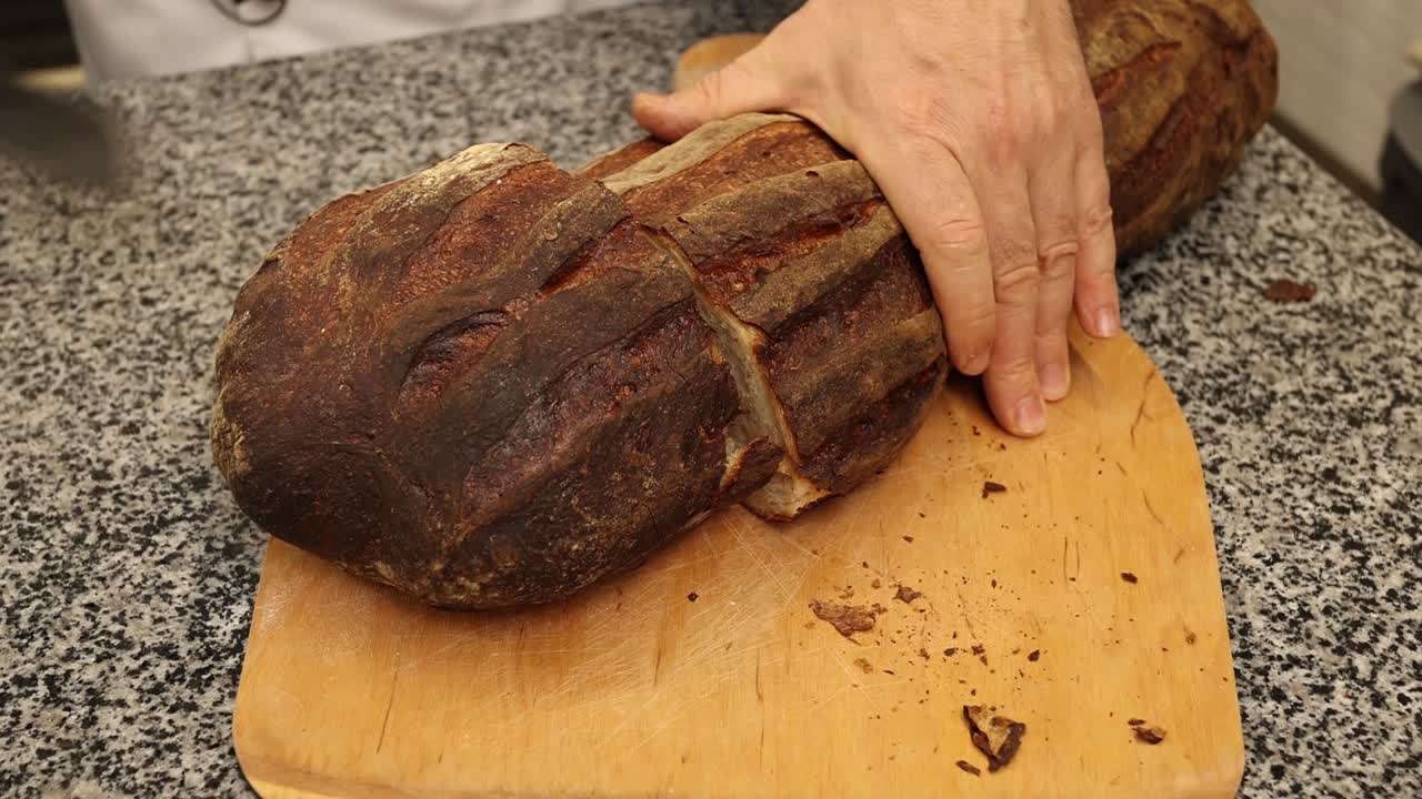 Taglio di una grande pagnotta di pane artigianale