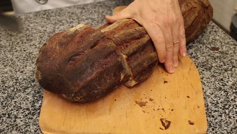 cortando un gran trozo de pan artesanal