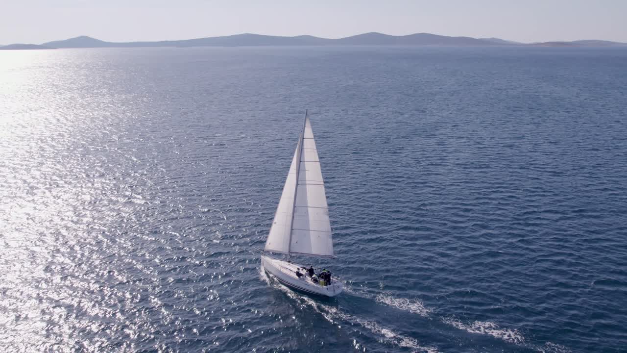 Zeilboot vaart over turquoise golven nabij de Kroatische kustlijn