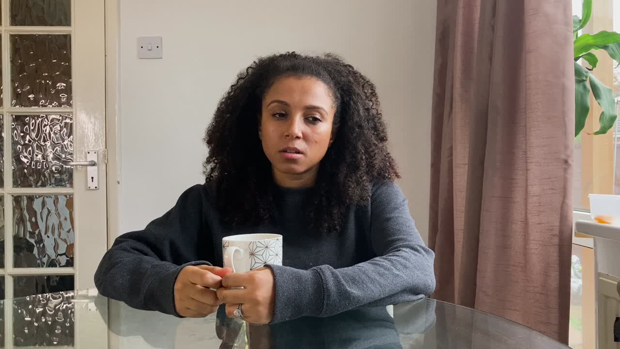 mujer joven en una videollamada que parece visiblemente deprimida mientras habla con el terapeuta