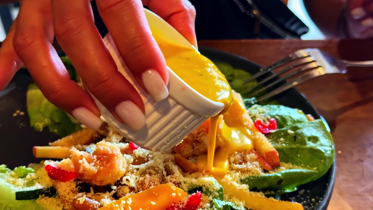 Insalata fresca con pezzi fritti dorati e verdure colorate servita su un piatto.