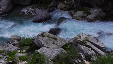 River-water-foaming-and-splashing-on-cliffs-of-Alpine-Mountains-in-Theth,-Albania