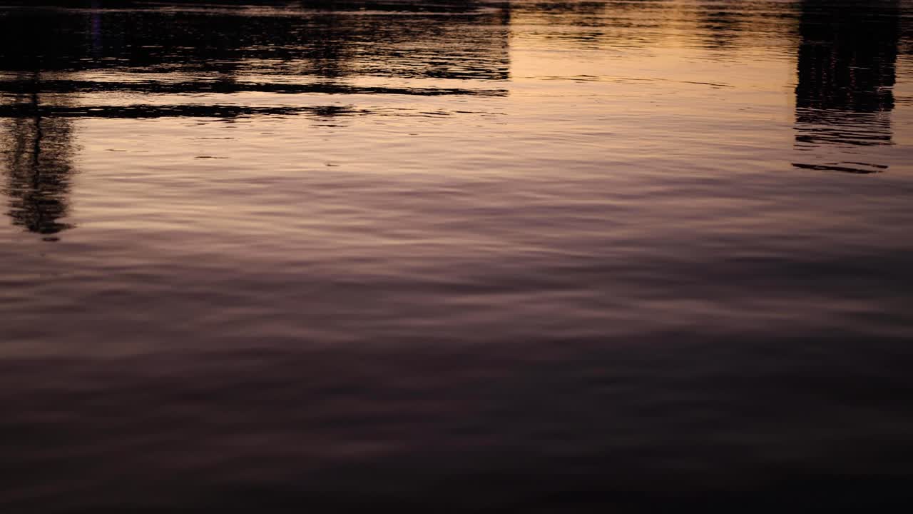 Sunset reflections on calm water surface