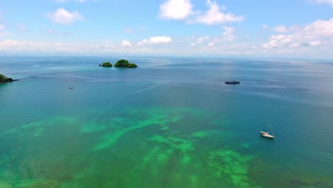 forward flight near anchored sailboat and view of distant islands