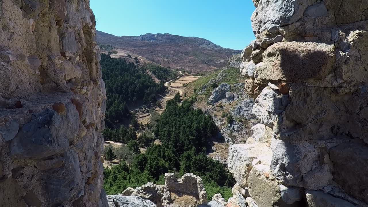 mirando a través de un hueco en la pared del castillo ruinas de paleo pili un sitio histórico en la isla de kos en grecia