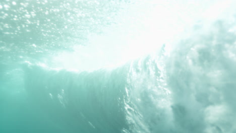 slow motion underwater inside curling wave, translucent textures and motion blur