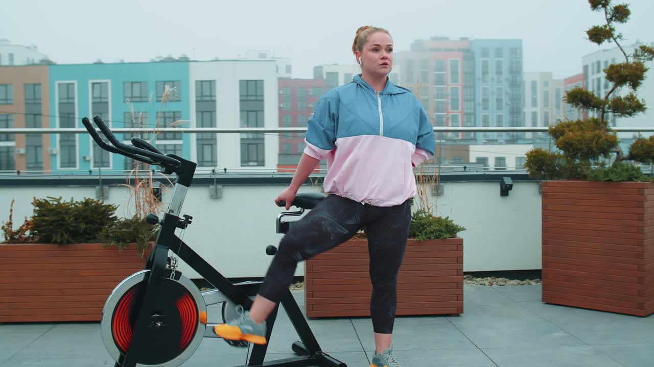 Woman performs aerobic endurance training workout cardio routine on the simulators cycle training