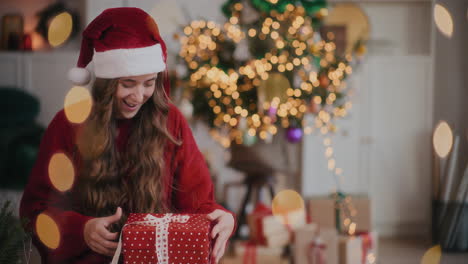 cheerful woman in santa hat catching christmas presents at home