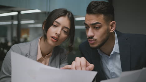 two business colleagues collaborating and reviewing documents in an office