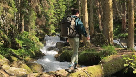 Hiking-woman-walk-with-a-hiking-backpack-in-spring-green-forest