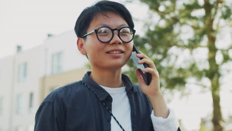 Young-Asian-Woman-Having-Phone-Talk-Outdoors