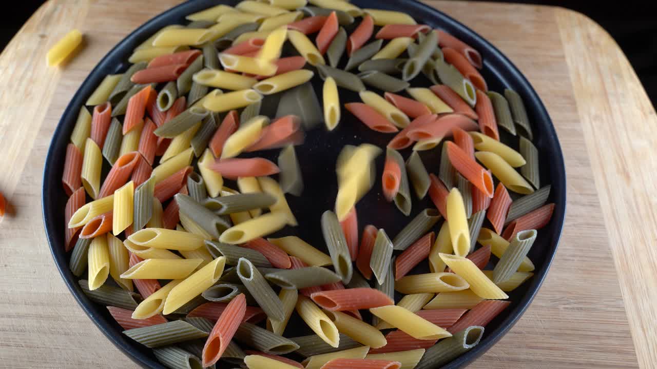 마카로니 파스타가 테이블 위에 있는 접시에 떨어집니다.